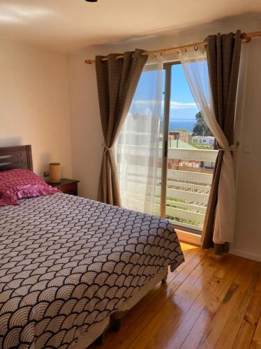 een slaapkamer met een bed en een groot raam bij Cabaña Pichilemu in Pichilemu
