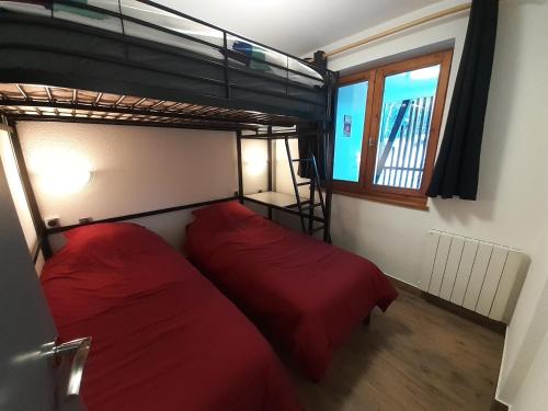 1 dormitorio con 2 camas y 1 litera en Superbe appartement en résidence skis aux pieds en Courchevel