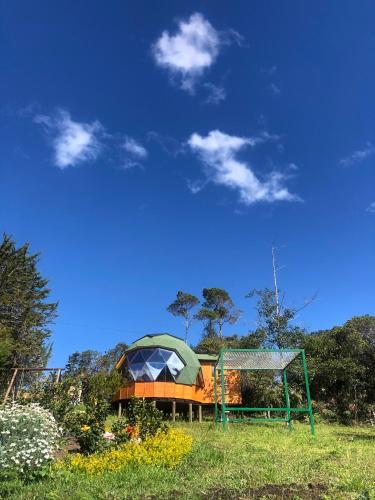 a building with a gazebo in a field at Glamping y Chalet Aventura Park Villa De Leyva La Periquera in Villa de Leyva