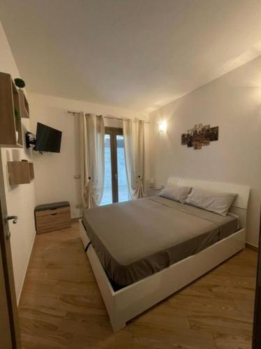 a bedroom with a large bed and a window at Casa Manzoni in La Maddalena