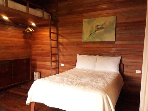 Un dormitorio con una cama con una escalera. en Posada Campo Libre, en Baeza