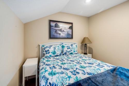 um quarto com uma cama com uma colcha azul e branca em Captain's Quarters - Cabana em Depoe Bay