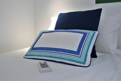 ein Kissen und eine Fernbedienung auf einem Bett in der Unterkunft Las Olas Blue in Playa del Ingles