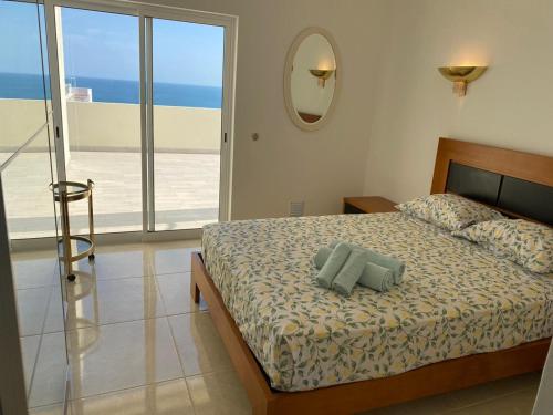 una camera con letto e vista sull'oceano di Apartamento com grandes terraços em frente a Praia a Portimão