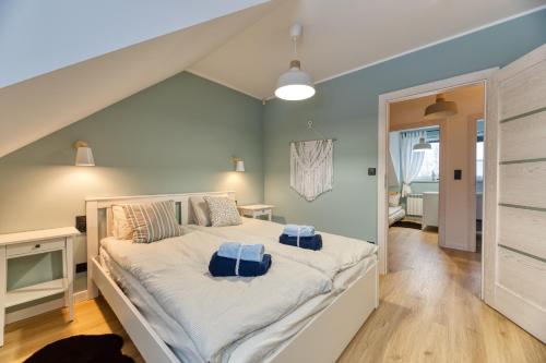 a bedroom with a large bed with blue pillows on it at Apartamenty Cichowierzbowo in Ściegny