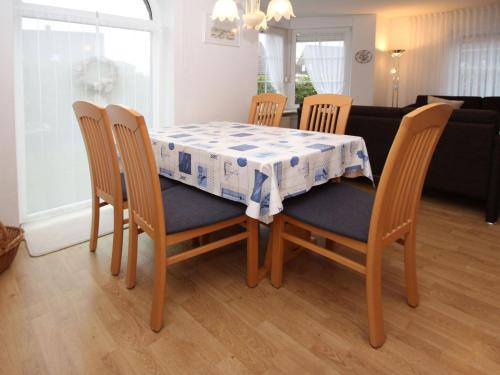 uma mesa de jantar e cadeiras com uma toalha de mesa azul e branca em Terraced house, Dornumersiel em Dornumersiel