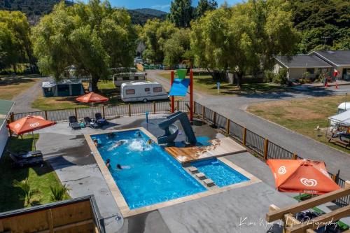 einen Luftblick auf einen Pool mit einem Wohnmobil und einem Resort in der Unterkunft Shelly Beach TOP 10 Holiday Park in Coromandel Town