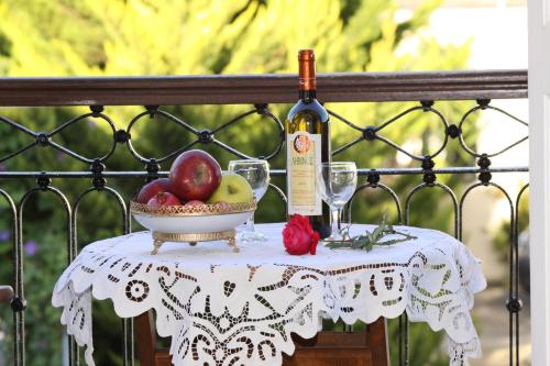 a table with a bowl of fruit and a bottle of wine at Artemis Traditional Hotel in Myrina