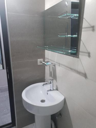 a white bathroom with a sink and a mirror at Hotel Ragnar in Nizhnyaya Alekseyevka