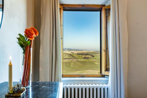 a vase of flowers on a table in front of a window at CASA ANNA in Laiatico