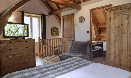 a bedroom with a bed and a tv on a dresser at Le Moulin de Lily in Palaiseau