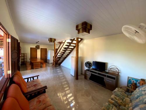 a living room with a couch and a staircase at Recanto Bela Vista Costa Dourada-BA in Costa Dourada