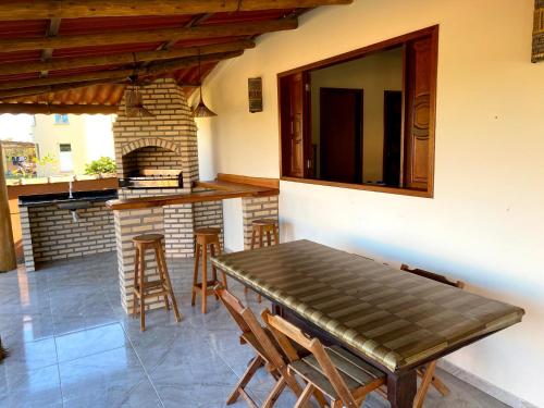 ein Esszimmer mit einem Tisch und einem Kamin in der Unterkunft Recanto Bela Vista Costa Dourada-BA in Costa Dourada