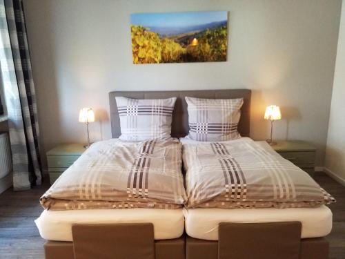 two beds in a bedroom with two lamps at Gästehaus Vinum in Leiwen