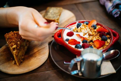 a person eating a bowl of cereal with fruit and granola at EVEN Hotel Eugene by IHG in Eugene