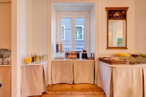 a room with two tables and a window at Solar dos Poetas in Lisbon