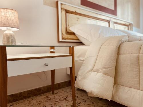 una camera con letto e tavolo con lampada di Il giardino di Iole Via Giovanni Amendola n36 a Sassari