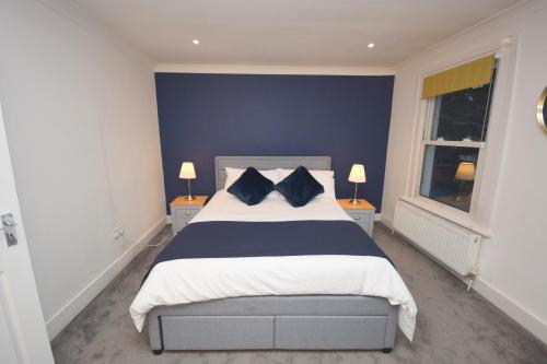 a bedroom with a large bed with blue walls at JB stays Greenwich, 3 bed house,ideal for contractors and family in London