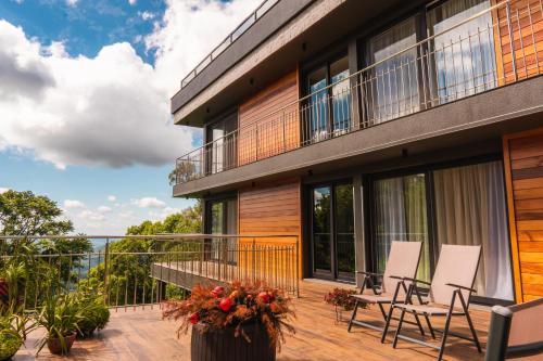 a balcony of a house with chairs on it at Suites Refugio Do Vale in Gramado