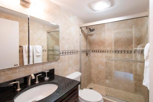 a bathroom with a sink and a toilet and a shower at Beach Living at Island Pine Villas BLAW in George Town