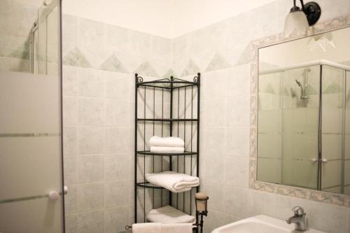 a bathroom with a towel rack next to a sink at All'ombra della Torre only Rooms in Siena
