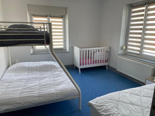 a bedroom with two bunk beds and a crib at Appartement saisonnier in Bussang