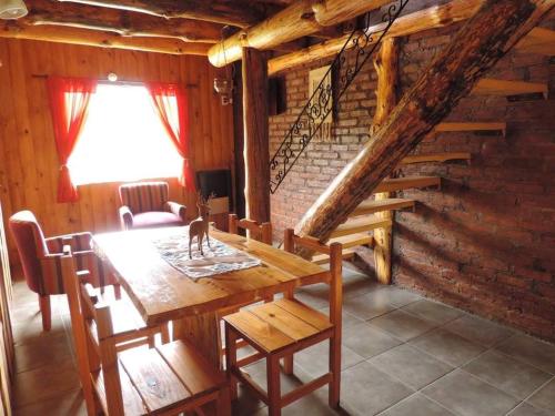 a dining room with a wooden table and a staircase at Las Cuatro Lunas in Villa Meliquina