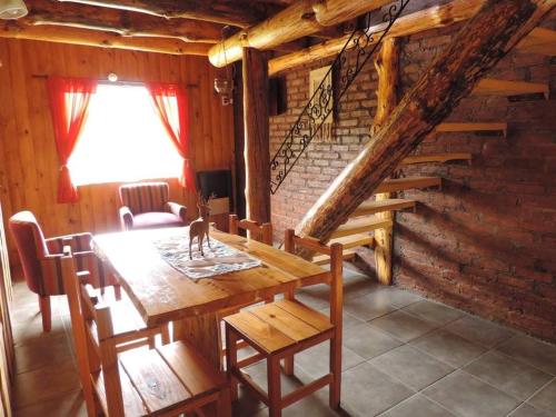 a dining room with a wooden table and a staircase at Las Cuatro Lunas in Lago Meliquina