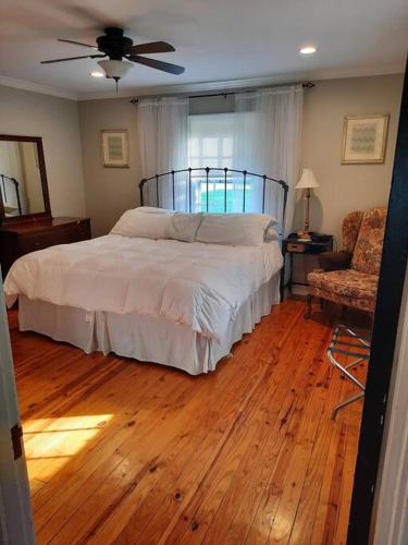 a bedroom with a bed and a wooden floor at Charming Cottage on a City Farm! in Lexington