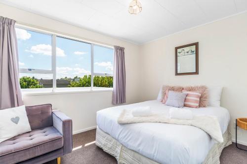 - une chambre avec un lit, une chaise et une fenêtre dans l'établissement Bach @ 38 - Taupo, à Taupo