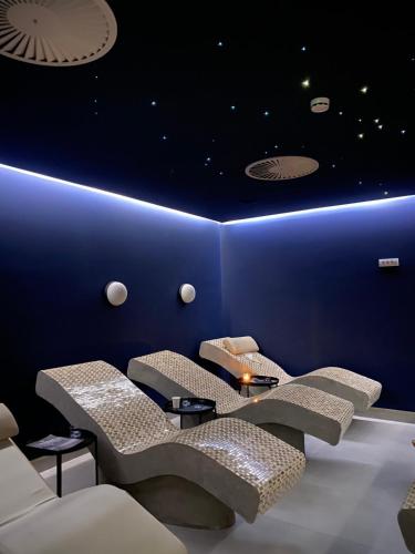 a room with four chairs and a blue wall at Pegaz009**** in Vrnjačka Banja