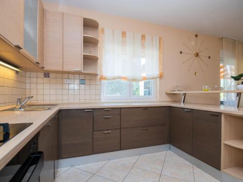 a kitchen with brown cabinets and a clock on the wall at Villa Secret Beauty with Heated Saltwater Pool in Imotski
