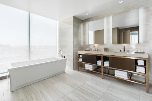 La salle de bains est pourvue d'une baignoire, d'un lavabo et d'un miroir. dans l'établissement Hyatt Regency JFK Airport at Resorts World New York, à Queens