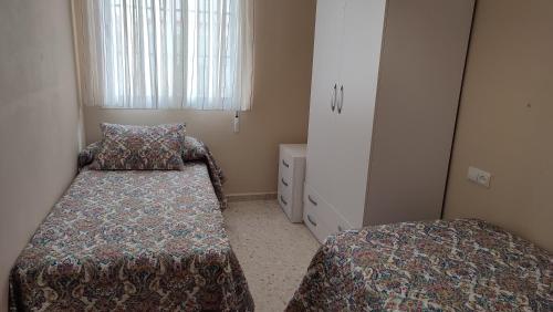 - une petite chambre avec 2 lits et une fenêtre dans l'établissement Apartamento Paseo Marítimo, Centro Torre del Mar, à Torre del Mar
