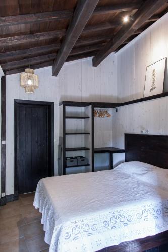 - une chambre avec un grand lit et un plafond en bois dans l'établissement Belle de Nuit - Gîte en Ardèche avec piscine et vue, à Malbosc