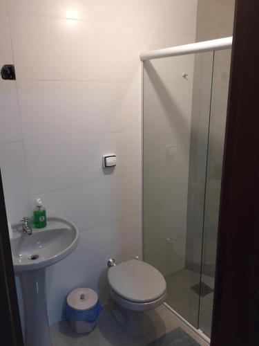a bathroom with a toilet and a glass shower at Flat ao lado do Shopping in Santa Cruz do Sul