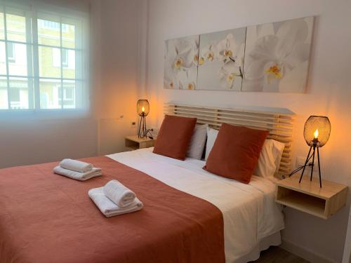 a bedroom with a large bed with two towels on it at BEACH FRONT ATICO WIFI in Tarifa