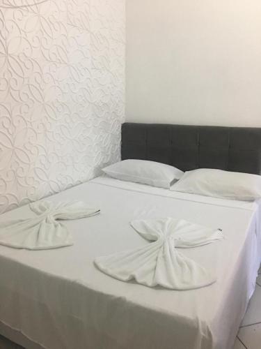 a white bed with two white towels on it at Pousada Canto Juquehy in Juquei