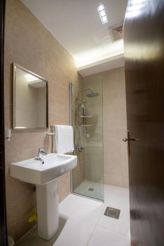 a bathroom with a sink and a shower at شقق ركن مدهال جازان للشقق المخدومة in Jazan