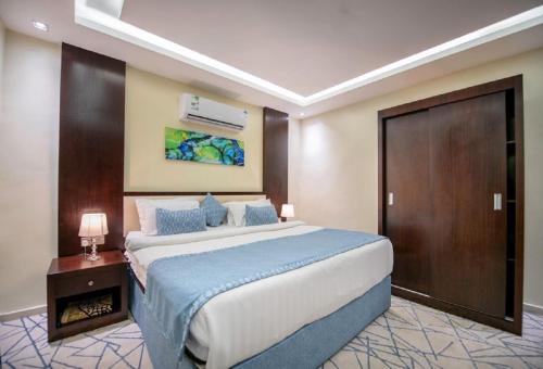a large bedroom with a large bed and a wooden door at شقق ركن مدهال جازان للشقق المخدومة in Jazan