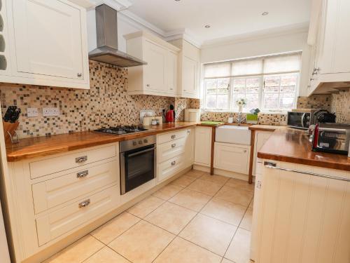 a kitchen with white cabinets and a stove top oven at 12 Deva Terrace in Chester