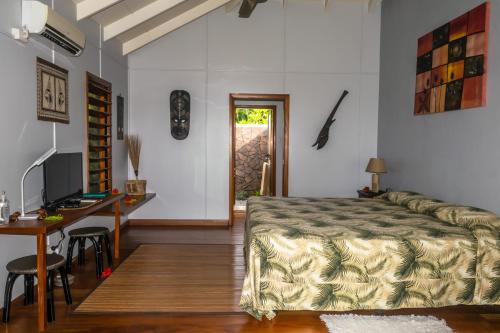 a bedroom with a bed and a table and a desk at Aroha Taveuni in Waiyevo