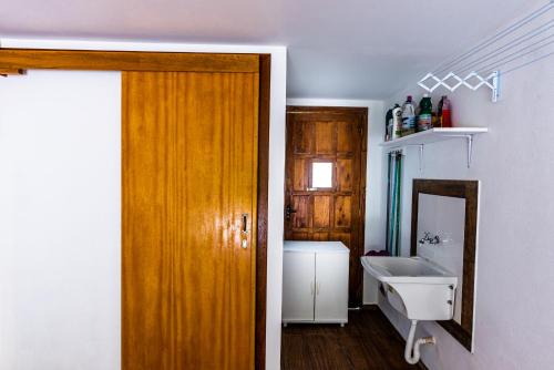 een badkamer met een houten deur en een wastafel bij Apartamento Completo de 3 quartos em Gramado 2 in Gramado