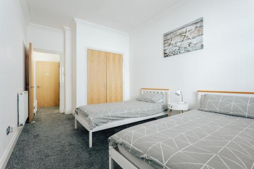 a bedroom with two twin beds and a closet at Spacious 2 bedroom flat near beach and town centre in Bournemouth