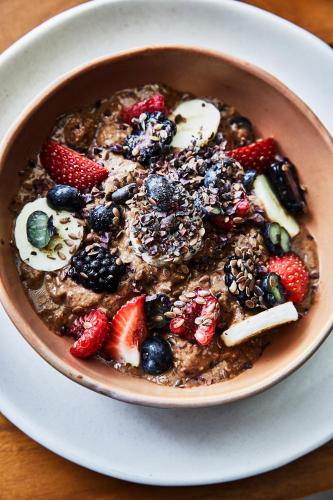 a bowl of oatmeal with fruit on a white plate at Etéreo, Auberge Collection in Playa del Carmen