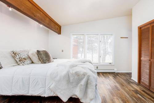 um quarto branco com uma cama e uma janela em Falke Inn em Anchorage