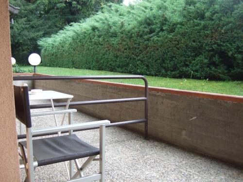 a balcony with a chair and a table and grass at Hotel Canturio in Cantù