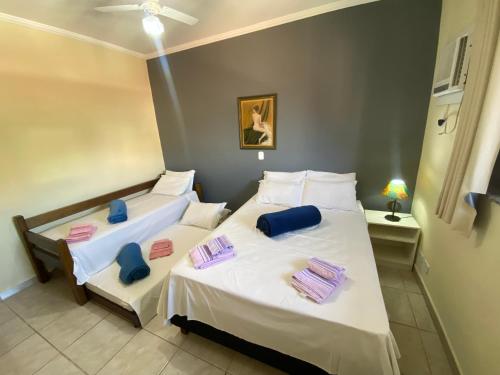 a bedroom with two beds with towels on them at Pousada Golden House - Próxima ao Thermas no Centro de Aguas in Águas de São Pedro