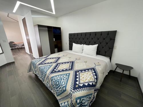a bedroom with a bed with a blue and white blanket at RAYON CANTERA in Morelia