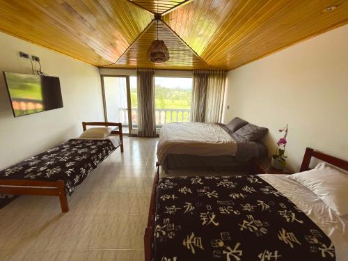 a hotel room with two beds and a window at Lujosa Casa Quinta en Naturaleza Andina in Iza